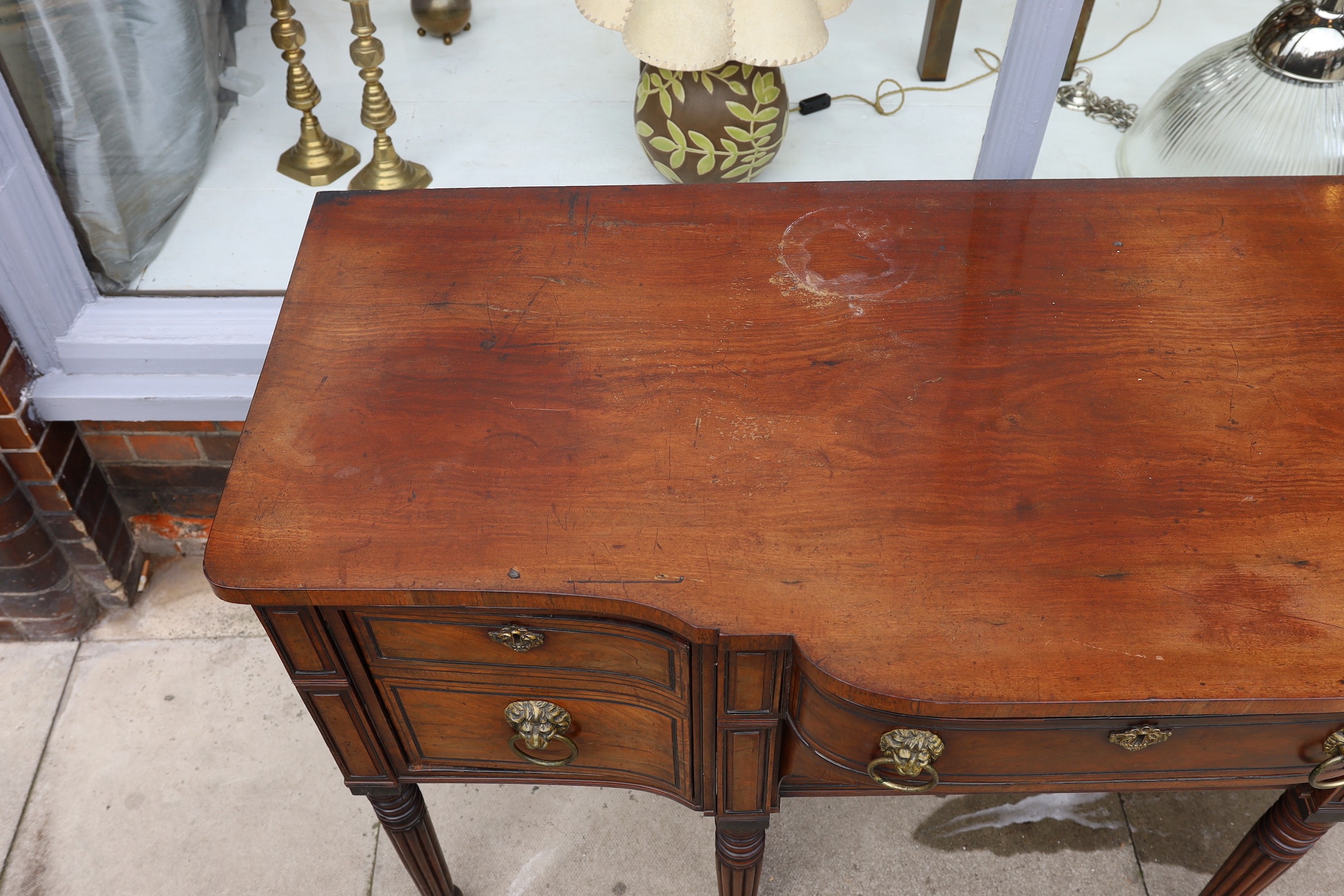 A Regency ebony strung mahogany breakfront sideboard, each deep drawer with ‘secret’ revolving cellaret compartment, centred with two long drawers, on ring turned fluted and tapered legs, width 167cm. depth 69cm. height